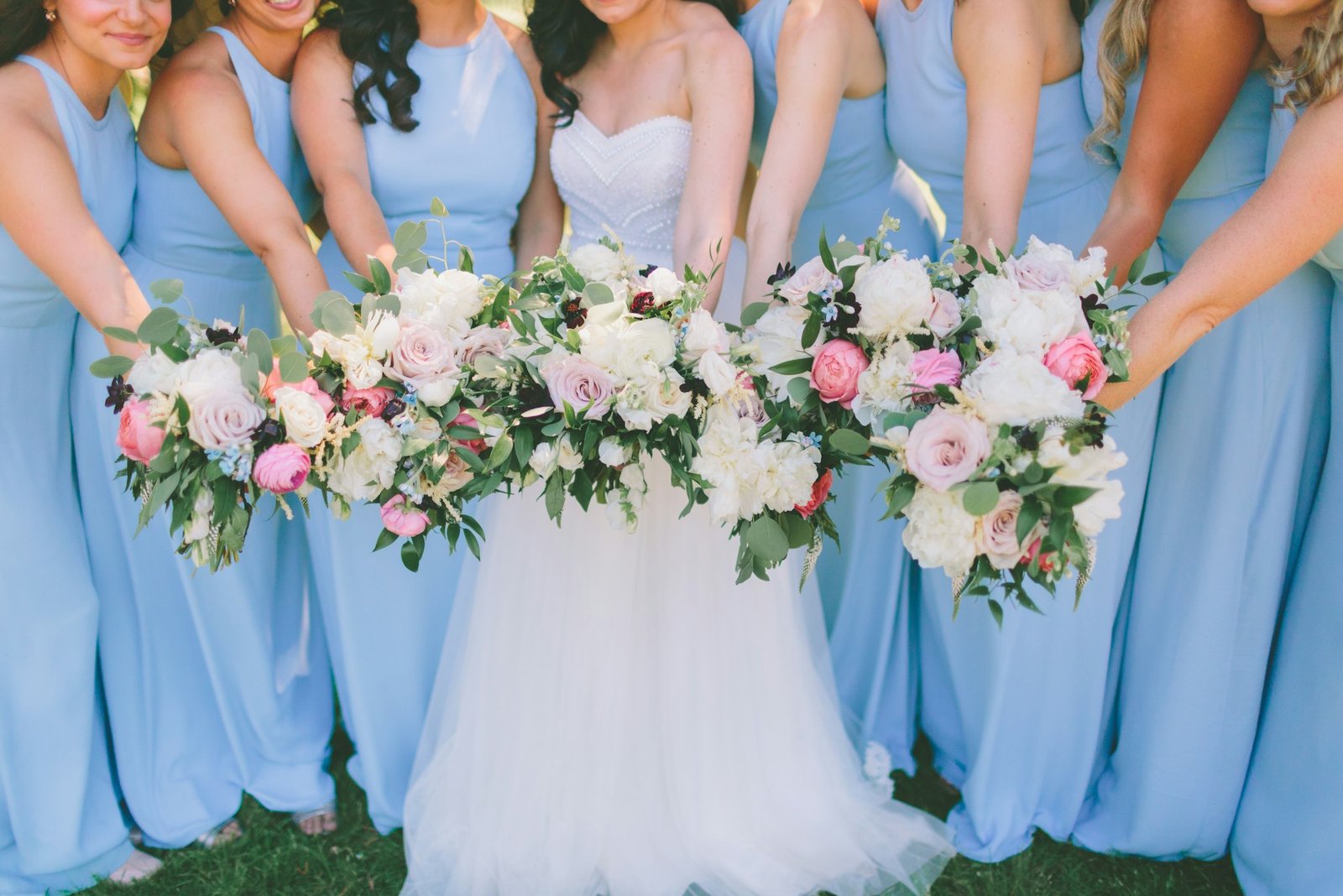 A bridal party dressed in blue holding onto their bouquets.